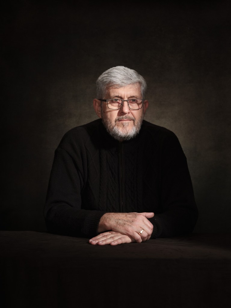 A fine art studio portrait of Oleksandr Maksymenko, Ukrainian journalist and survivor advocate from the ALUMNI network, for the "Survivors in Defence of ICC" project in The Hague, Netherlands, photographed by De Sheng Lim.